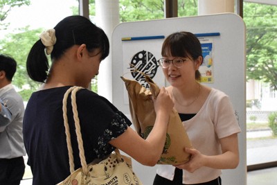 学生フードバンクソレイユで共同代表を務める大岩柚実さんが受け取りに来た学生に米5キロを手渡した＝新潟市西区で2025年6月24日午後4時42分、戸田紗友莉撮影