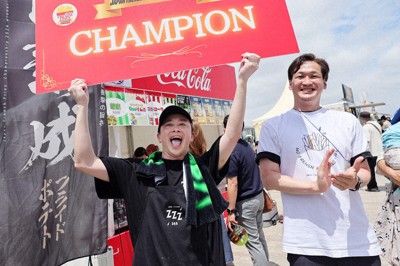 大会で優勝しボードを掲げる「zzz365」代表の上野博貴さん（左）と日本フライドポテト協会の佐藤雄太代表理事