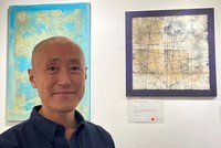 Diplomat and abstract sand artist Takashi Hattori and his work titled 