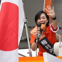 聴衆に向けて手を振る参政党の梅村みずほ氏＝大阪市北区で2025年7月3日、岡崎英遠撮影