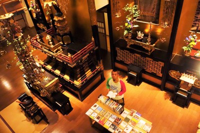 専立寺の本堂内に並ぶ書籍と日野岳史乗住職＝盛岡市で5月16日午後8時6分、高橋昌紀撮影