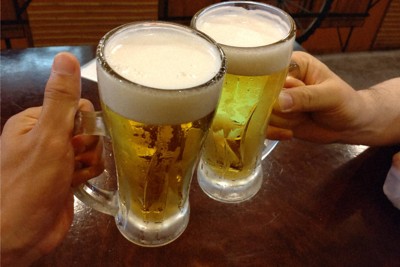 居酒屋でビールで乾杯する人ら