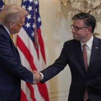 トランプ米大統領（左）と握手する連邦議会のジョンソン下院議長＝米ホワイトハウスで2025年7月22日、AP