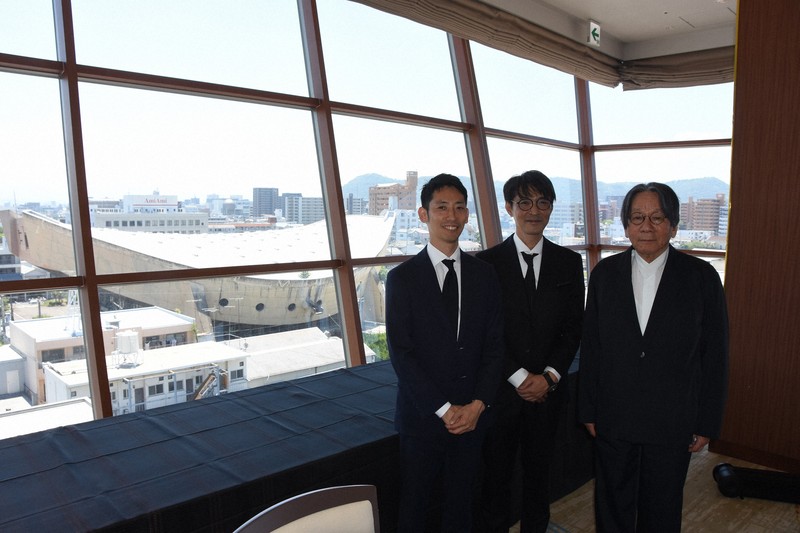 行政に財政負担を求めない耐震改修・活用案を発表した「旧香川県立体育館再生委員会」の（左から）上杉昌史副委員長、長田慶太委員長、青木茂理事。窓外左側に見えているのが旧県立体育館＝高松市で2025年7月23日午後0時54分、森田真潮撮影
