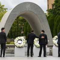 原爆慰霊碑の献花を終え、岸田文雄首相（右から2人目）の背中に手をやるフランスのエマニュエル・マクロン大統領（同3人目）。左端はカナダのジャスティン・トルドー首相、右端は米国のジョー・バイデン大統領＝広島市中区で2023年5月19日（外務省提供）
