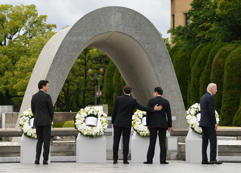 原爆慰霊碑の献花を終え、岸田文雄首相（右から2人目）の背中に手をやるフランスのエマニュエル・マクロン大統領（同3人目）。左端はカナダのジャスティン・トルドー首相、右端は米国のジョー・バイデン大統領＝広島市中区で2023年5月19日（外務省提供）