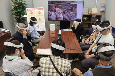 児玉光雄さんの被爆体験を映像化したVR体験会の参加者たち＝広島市中区で2025年5月3日午後3時12分、安徳祐撮影
