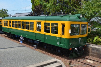 「かぼちゃ電車」として親しまれた旧新潟交通電車線の旅客電車「モハ11号」。今回の修復で緑と黄の色鮮やかな外観がよみがえった＝新潟市南区で2025年7月27日、神崎修一撮影