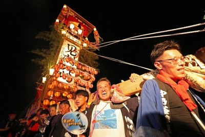 珠洲市宝立町地区で2年ぶりに立ち上がったキリコを各町会から集まった担ぎ手たちは喜びの表情を浮かべながら担いでいた＝石川県珠洲市で、岩本一希撮影