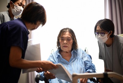 三宅文枝さん（左から2人目）と一緒に、完成した証言集に目を通す森田トメヲさん（同3人目）＝広島県廿日市市で2025年8月2日午後1時18分、佐藤賢二郎撮影
