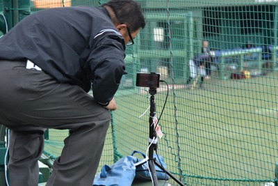 試合前にビデオ検証用のスマートフォンを設定する仙台六大学野球連盟の菊地正志審判＝仙台市の東北福祉大野球場で2025年5月24日、長宗拓弥撮影