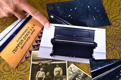 母セツさんと寄贈した被爆ピアノの写真を指さす松田勝三さん。現物は長崎原爆資料館の収蔵庫に保管されており、被爆当時のガラス片が刺さったままという=長崎市で2025年6月30日、北山夏帆撮影