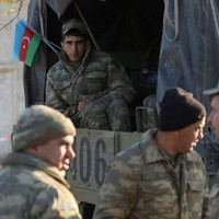 アルメニア側との係争地だったナゴルノカラバフの街アグダムに集まったアゼルバイジャンの軍人たち＝2020年11月24日、ロイター