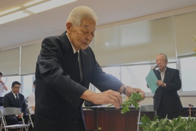 慰霊祭で花を手向ける六田正英さん＝長崎市竹の久保町で2025年8月9日午前11時40分、添谷尚希撮影