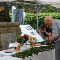 慰霊の碑に献花し、手を合わせた参列者＝長崎県諫早市で2025年8月11日午前11時12分、松尾雅也撮影