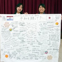 寄せ書きを掲げる河野錫さん（左）と只野杏奈さん＝只野さん提供