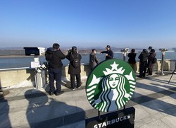 スターバックスの店舗のそばには望遠鏡が設置されており、川の対岸に広がる北朝鮮の風景を見ることができる＝韓国北西部・金浦市で2024年11月29日、福岡静哉撮影
