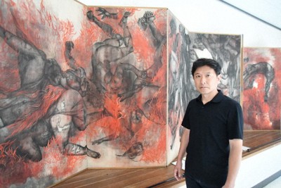 原爆の図を前にして「丸木夫妻の思いを未来に向けて受け継ぐ新しい感覚のアーティストを支援したい」と語る岡村幸宣さん＝埼玉県東松山市の原爆の図丸木美術館で2025年8月8日午後0時18分、仲村隆撮影