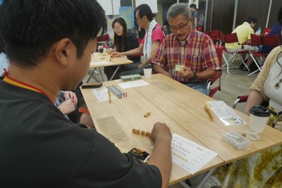 2対2の4人で対戦する「ごいた」。能登ごいた保存会理事長の佐野勝二さん（中央奥）も卓を囲んだ＝大阪府八尾市で2025年8月24日