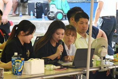 場内アナウンスで決まり手を伝える拓殖大相撲部マネジャーの谷愛優菜さん（左から2人目）＝東京都千代田区の靖国神社相撲場で2025年7月27日午後2時24分、大村健一撮影
