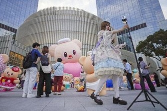 商業施設の前で自撮りをする人＝5月、中国上海市