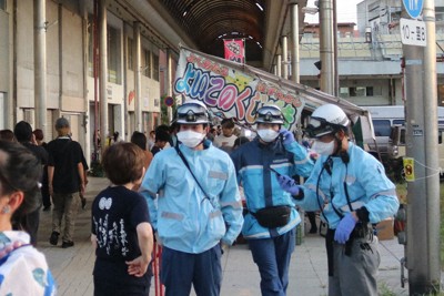 ガス漏れの通報を受け、出動したとみられる救急隊員＝福岡県大牟田市のアーケード街で2025年7月27日午後7時15分ごろ、降旗英峰撮影