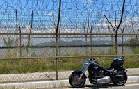 The author's Harley-Davidson Fat Boy 114 is seen on Ganghwado island, northwest of Seoul, Aug. 2, 2025. Beyond the barbed-wire fences and a river is North Korea. (Mainichi/Tatsuma Kasama)