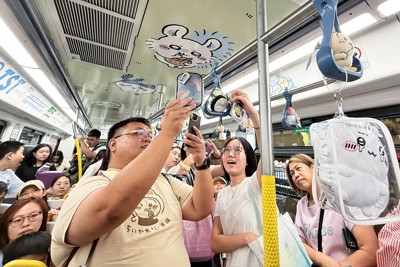 ラッピング路面電車に「ちいかわ」グッズを持ち込み撮影するファンら（8月24日、筆者撮影）