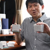 好きな音楽を集めた自作のMDを手にする栗田朋一さん。後方にあるコンポは壊れていてMDが聴けないという＝さいたま市で、宮本明登撮影