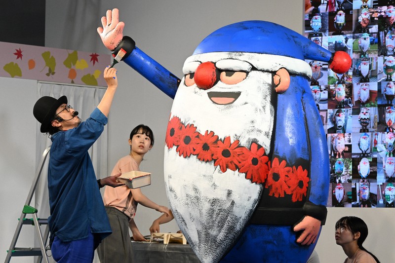 100体目のサンタ」は何色? 万博に登場、絵本作家が色塗り実演 | 毎日新聞