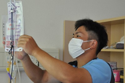 慣れた手つきで栄養剤の準備をする佐伯市野球団の田川大智選手＝大分県佐伯市で2025年7月30日、角田直哉撮影