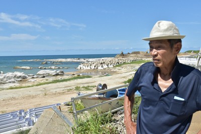 能登半島地震の隆起した海岸で、ふるさとの再生について語る元区長の谷内謙一さん。谷内さんらは隆起した土地に災害公営住宅の建設を求めている＝石川県珠洲市で2025年9月3日午後1時21分、中尾卓英撮影
