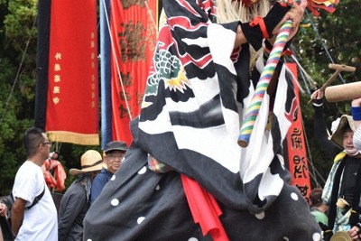 枠旗を先導する天狗（てんぐ）のお面をかぶった猿田彦＝石川県七尾市で2025年9月20日午後0時57分、島袋太輔撮影