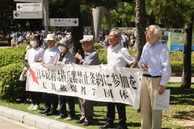 横断幕を掲げて署名を呼びかける参加者＝広島市中区の平和記念公園で2025年9月22日午後0時43分、井村陸撮影