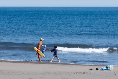 風で飛ばされた浮輪を子どもに渡す國澤健大さん（25）。日体大ライフセービング部OBで、川崎市の高校で非常勤で保健体育を教えながら活動を続ける。「一日一日、海をなめないように」＝神奈川県湯河原町で2025年8月20日、吉田航太撮影