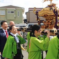 選挙区の祭りに参加し、スーツ姿でみこしを担ぐ自民党の土田慎財務政務官＝東京都足立区で2025年9月13日午後2時54分、田中裕之撮影