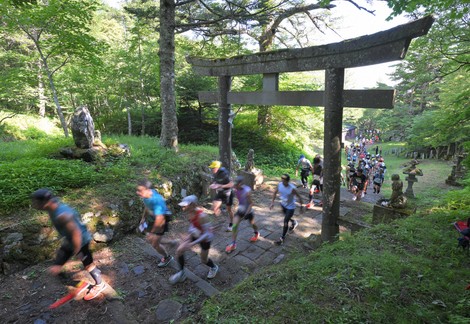 吉田口登山道で「馬返し」の鳥居をくぐり、山頂を目指す「富士登山競走」の選手たち。3363人が参加した。鳥居には「文政九年」（1826年）の文字が刻まれている＝山梨県富士吉田市で2025年7月25日、手塚耕一郎撮影