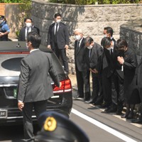 自宅に到着した安倍晋三元首相の遺体を乗せた車両に手を合わせる自民党の高市早苗政調会長（右から2人目）ら＝東京都渋谷区で2022年7月9日午後1時38分、宮間俊樹撮影