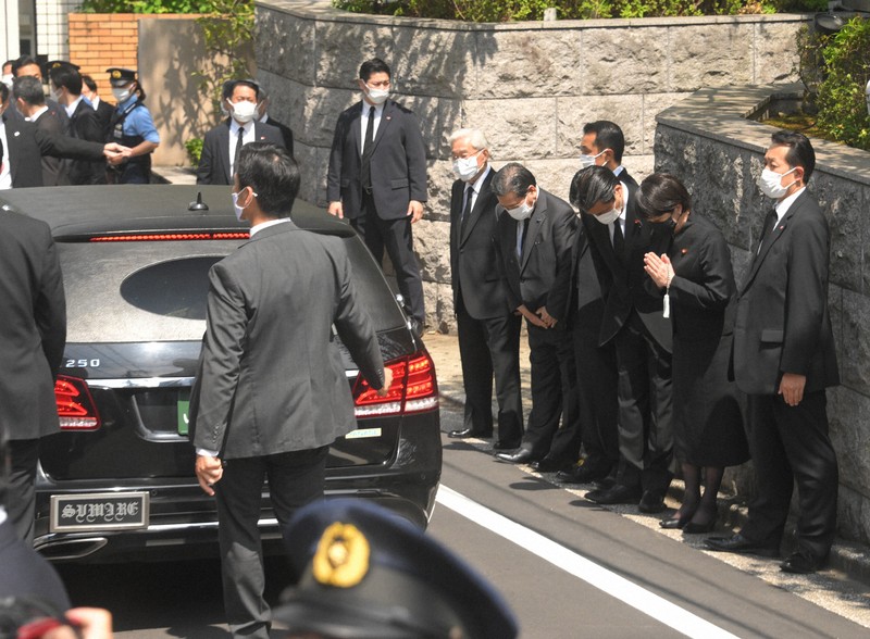 自宅に到着した安倍晋三元首相の遺体を乗せた車両に手を合わせる自民党の高市早苗政調会長（右から2人目）ら＝東京都渋谷区で2022年7月9日午後1時38分、宮間俊樹撮影