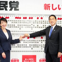 衆院選投開票日に岸田文雄首相（右）と当選の花を付ける高市早苗政調会長＝東京都千代田区永田町の自民党本部で2021年10月31日、代表撮影