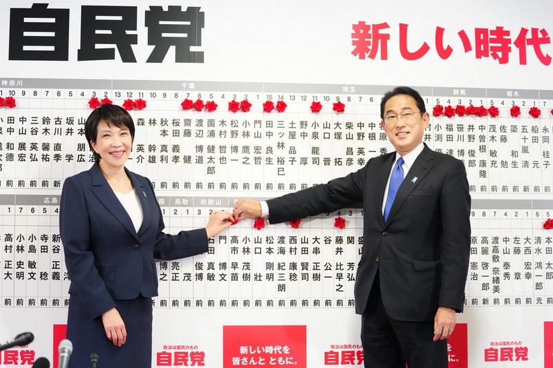 衆院選投開票日に岸田文雄首相（右）と当選の花を付ける高市早苗政調会長＝東京都千代田区永田町の自民党本部で2021年10月31日、代表撮影