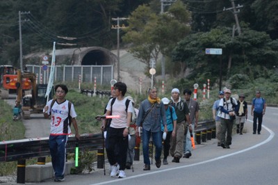 米坂線の運休区間の線路近くを歩く「テクテク100」の参加者＝新潟県村上市で2025年9月28日、神崎修一撮影