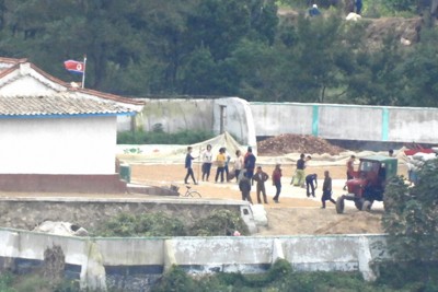北朝鮮・黄海北道開豊郡の村。朝鮮労働党の創建80周年が近づき、いつもは無い場所に国旗が掲揚され、住民が作業に追われていた＝韓国北西部・金浦市から2025年10月9日午後3時3分、福岡静哉撮影（超望遠カメラを使用）