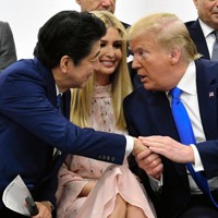 「女性のエンパワーメントに関する首脳特別イベント」の会場で、米国のイバンカ大統領補佐官(中央)を挟んで握手する安倍晋三首相(左)とトランプ米大統領=大阪市住之江区で2019年6月29日(代表撮影)