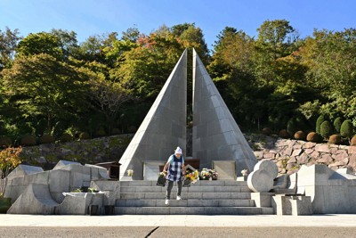 日航ジャンボ機墜落事故の犠牲者を追悼する「慰霊の園」で供えられた花の水替えを行う女性＝群馬県上野村で2025年10月8日、平川義之撮影