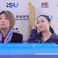 女子SPで演技を終え、汗を拭いながら得点を見つめる松生理乃（右）＝中国・重慶で2025年10月24日、吉田航太撮影