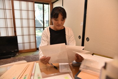 取材した関係者の資料や手紙を読み返し、懐かしむ道脇紗知さん＝福島県いわき市で2025年7月、柿沼秀行撮影