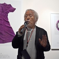 写真展会場で展示されている被爆資料について解説する土田ヒロミさん。写真の下には資料に関する情報が付記されている＝大阪市北区で2025年6月28日、佐藤賢二郎撮影