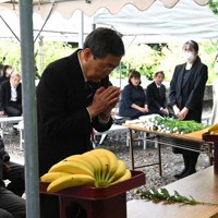 京都府原爆死没者慰霊碑に献花し、手を合わせる府原爆被災者の会の林昌也会長＝京都市東山区で、日高沙妃撮影