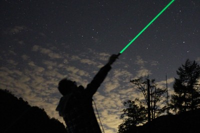 長野県阿智村の星空解説でレーザーポインターを使って説明する星兄さん＝阿智☆昼神観光局提供
